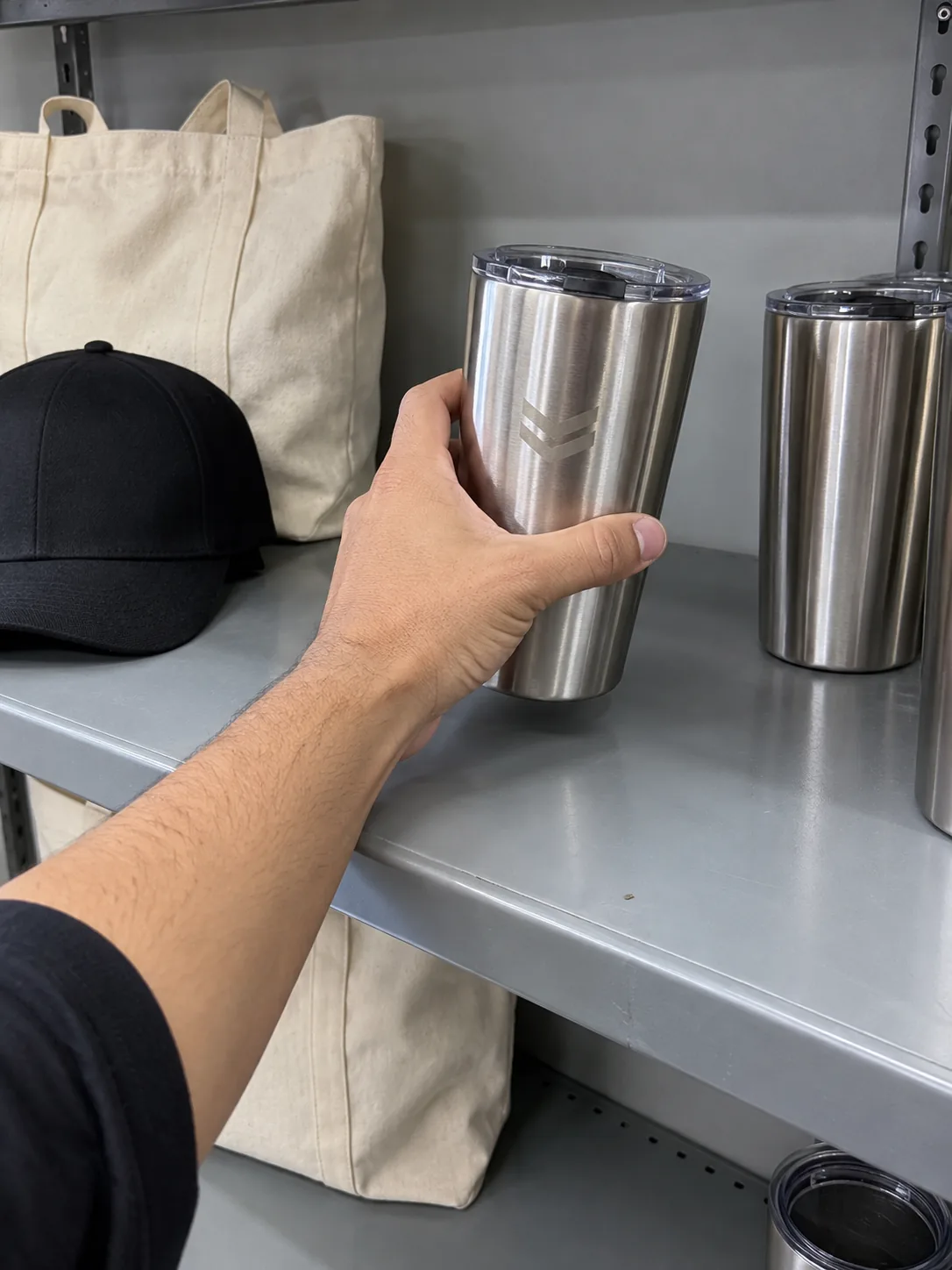 Caps, tumblers and tote bags on a shelf